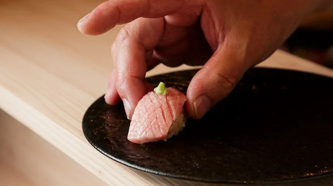 白木の下駄に並べた握り寿司を仕上げる直前の様子